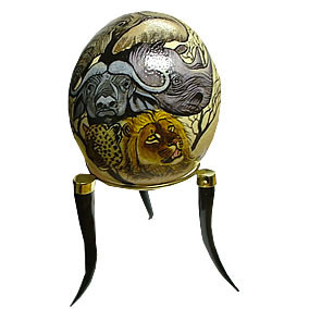 This ostrich egg is a very strong one and is mostly used as an exhibition, it has a tripod stand that carries the egg, this stand is black tiny and a tip that holds it on a smooth surface, it has a ring that bounds all three together, this ostrich egg has a mix drawing and color of gold, silver and brown 15cm in diameter. Beautiful drawings can be made on an ostrich egg